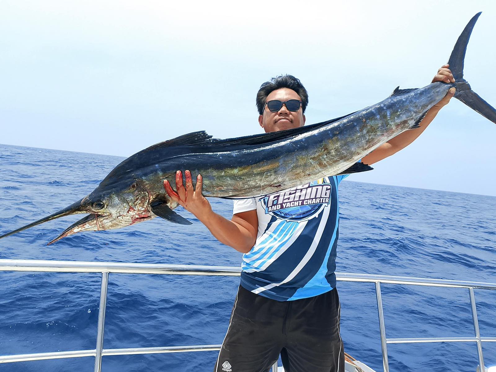 Angler holding a marlin offshore
